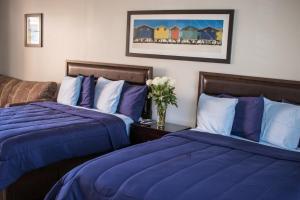 A bed or beds in a room at Riptide Oceanfront Hotel
