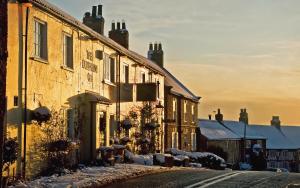 a row of houses with snow on the ground at The Durham Ox in Crayke