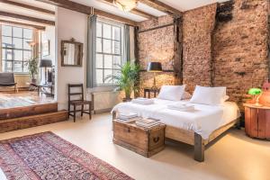 1 dormitorio con cama y pared de ladrillo en Classy Room 17th C Canalhouse en Ámsterdam