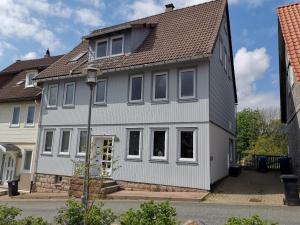una casa grigia e bianca con tetto marrone di Tolles Ferienhaus mit großem Garten für 9 Personen erwartet Sie im Harz! a Sankt Andreasberg