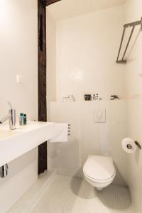 Baño blanco con aseo y lavamanos en Classy Room 17th C Canalhouse en Ámsterdam
