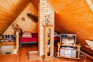 una sala de estar con TV y un sofá en una cabaña en Guest House Šampētera māja, en Riga