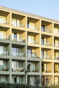 an apartment building with chairs in front of it at Vila Foz Hotel & SPA - member of Design Hotels in Porto