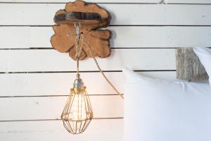 a light fixture hanging from a wall next to a pillow at Strandhotel Westduin in Koudekerke