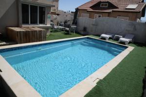 a swimming pool in the backyard of a house at Villa Sea House in Eilat