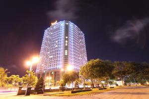 Un grand bâtiment avec des lumières allumées la nuit dans l'établissement Baymax Home Apartment 2BR Riverview, à Nha Trang