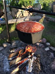 a pot of food is cooking on a fire at Viesu nams Zivtiņi in Kaltene