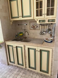 a kitchen with green and white cabinets and a sink at Tramari in Taranto