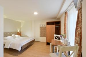 a hotel room with a bed and a desk and a table at Hotel Hirschen in Zürich