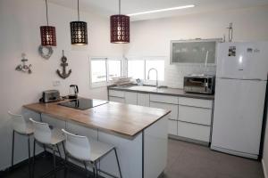 eine Küche mit einem weißen Kühlschrank und einer hölzernen Arbeitsplatte in der Unterkunft Villa Sea House in Eilat