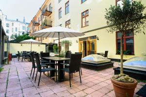 a patio with a table and chairs and an umbrella at Rex Hotel in Stockholm