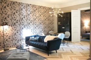 uma sala de estar com um sofá azul e um mural de parede em EDEN APARTMENT em Riga