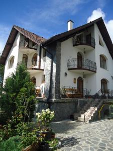 Casa blanca grande con balcones y patio en Pensiunea Crocus - Sauna & Billiard en Poiana Brasov