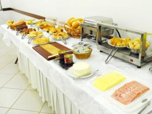 una mesa con un buffet de comida. en Hotel Veneza, en Ibaté