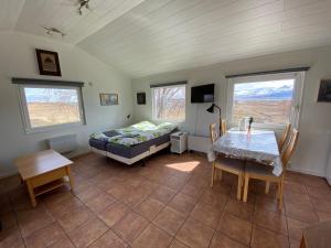 a bedroom with a bed and a table and chairs at Lækjarkot Rooms and Cottages with Kitchen in Borgarnes