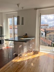 a kitchen with a table and chairs and a large window at Appt 5pers Centre St Jean de Luz - Calme - Grande Plage à 2mn - Balcon in Saint-Jean-de-Luz