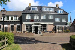 a black building with a sign that reads digoxin at Hotel "De Klok" in Buren