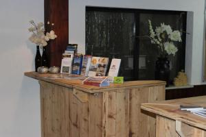 a wooden counter with books on top of it at Hotel Cafe Restaurant "De Klok" in Buren