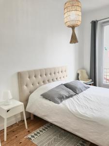 a bedroom with a large bed and a chandelier at Appt 5pers Centre St Jean de Luz - Calme - Grande Plage à 2mn - Balcon in Saint-Jean-de-Luz