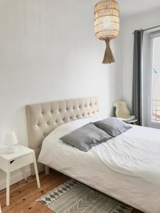 une chambre avec un grand lit et un lustre dans l'établissement Appt 5pers Centre St Jean de Luz - Calme - Grande Plage à 2mn - Balcon, à Saint-Jean-de-Luz