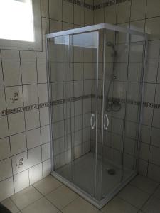a shower with a glass door in a bathroom at La Petite Source in Montendre