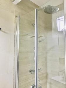 une salle de bain avec une douche avec une porte vitrée dans l'établissement Appt 5pers Centre St Jean de Luz - Calme - Grande Plage à 2mn - Balcon, à Saint-Jean-de-Luz