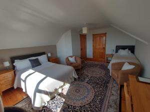 a bedroom with two beds and a desk and a chair at Inishowen Lodge B&B in Moville +12 photos