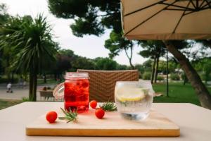 a wooden cutting board with a drink and a glass at Best Western Hôtel des Thermes - Balaruc les Bains Sète in Balaruc-les-Bains