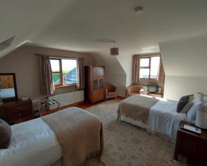 a hotel room with two beds and a living room at Inishowen Lodge B&B in Moville