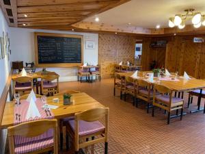 ein Restaurant mit Holztischen und -stühlen und einer Tafel in der Unterkunft Hotel Schiffahrt in Mols