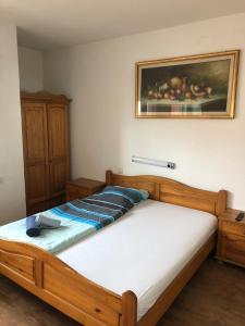 una camera con letto in legno e una foto appesa alla parete di Hotel Stadt-Lindau a Neu-Ulm