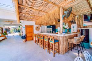 a kitchen with a bar with chairs and a table at So KohKoon Beach Resort in Bang Rak Beach