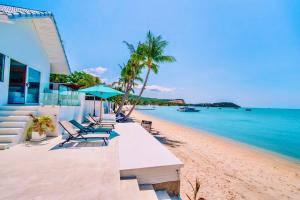 a beach with chairs and a house and the ocean at So KohKoon Beach Resort in Bang Rak Beach