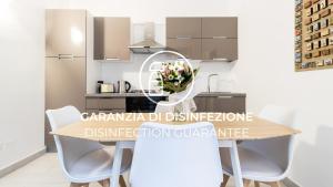 een keuken met een houten tafel en witte stoelen bij Italianway - Corso Cavallotti 223 in Sanremo