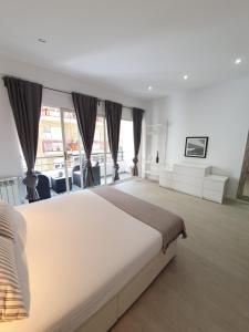 a large bedroom with a large bed and windows at CasaMila Guest House in Alicante