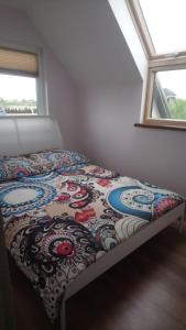 Ce lit se trouve dans une chambre dotée d'un couvre-lit coloré. dans l'établissement Apartamenty u Beaty, à Rewal