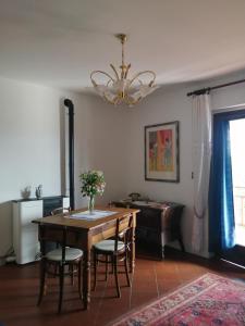 a dining room with a table and a piano at Le Viole Bianche in Albiano dʼIvrea