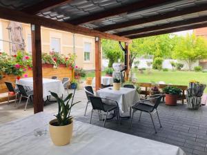 an outdoor patio with tables and chairs and a statue at PensionLien in Köthen