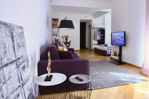a living room with a purple couch and a table at Palazzina B - Contemporary Studio in Genova