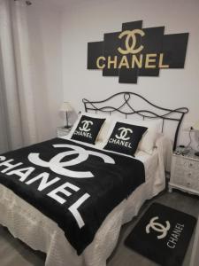 1 dormitorio con 1 cama con letrero de Chanel en la pared en Apartamentos SEOANE, en Finisterre