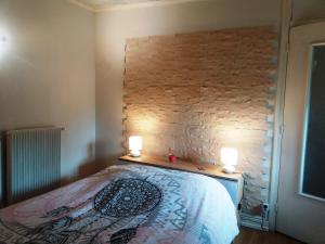 een slaapkamer met een bed met twee verlichting bij L'Horizon in La Burbanche