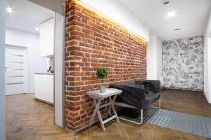 a brick wall in a room with a chair and a table at Dream Aparts - Rewolucji in Łódź