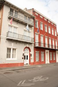 a building with american flags on the side of it at Grenoble House in New Orleans