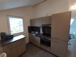 een kleine keuken met een fornuis en een raam bij Haus Putzas Appartment in Niedernsill