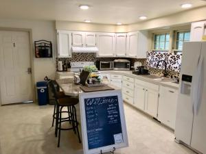 a kitchen with white cabinets and a counter with a chalkboard at The Little Italy of Niagara Falls Bed & Breakfast in Niagara Falls