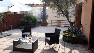 een patio met stoelen, een tafel en een parasol bij Home Scalzi 18 in Verona