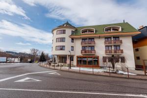 een groot wit gebouw aan de kant van een straat bij Apartmán 15 MyMara in Bešeňová