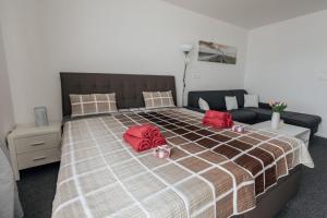 Un dormitorio con una cama con almohadas rojas. en Apartmán 15 MyMara en Bešeňová