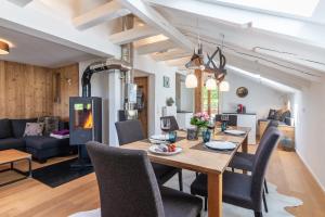 a dining room and living room with a table and chairs at Der Hochsitz in Bad Wiessee