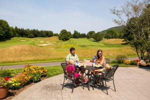 a family sitting at a table in a patio at Mountain Lodge at Okemo-1Br Fireplace & Updated Kitchen condo in Ludlow +12 photos